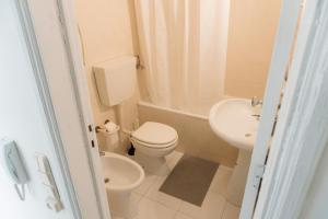a small bathroom with a toilet and a sink at Happy House in Quarteira +13 photos