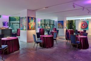 a room with tables and chairs and paintings on the walls at Renaissance New Orleans Arts Warehouse District Hotel in New Orleans