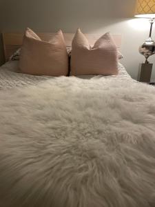 a white bed with two pillows on top of it at Zen Queen Room in West Kelowna