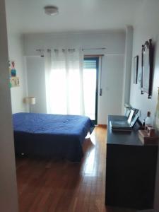 a bedroom with a bed and a desk and a window at Cascais Luxury Top Floor Apt in Cascais