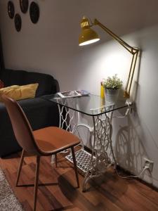 a glass table in a living room with a lamp and a chair at Sun Apart Vuorenrinne in Kotka