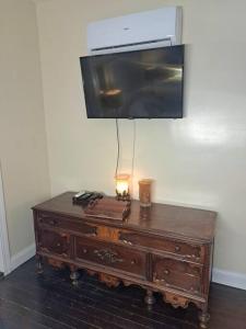 a tv on top of a wooden dresser with a lamp on it at Sunset Studio with Full Kitchen and no fee in Florence