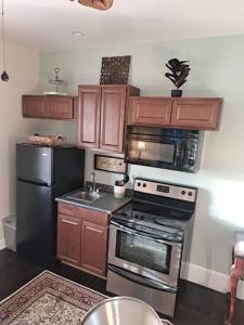 a kitchen with stainless steel appliances and wooden cabinets at Sunset Studio with Full Kitchen and no fee in Florence