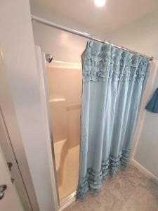 a shower with a blue shower curtain in a bathroom at Sunset Studio with Full Kitchen and no fee in Florence