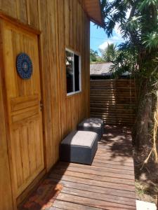 eine Veranda mit einer Tür und zwei Hockern darauf in der Unterkunft Casa do Campo in Ilha do Mel
