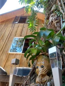 Una estatua de un bebé gruñón en un árbol en Casa do Campo en Ilha do Mel