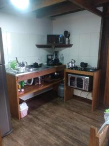 a small kitchen with a sink and a microwave at Casa do Campo in Ilha do Mel