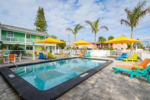 a swimming pool with chairs and umbrellas at a resort at The Lofts at St Pete Beach in St. Pete Beach