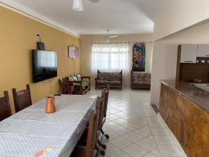 a kitchen and living room with a table and a television at Casa no Centro de Peruibe in Peruíbe +26 photos
