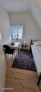 Schlafzimmer mit einem Bett, einem Tisch und einem Fenster in der Unterkunft Monteur Villa Kassel in Vellmar