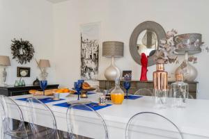une salle à manger avec une table blanche et des chaises dans l'établissement Villa Louis - Welkeys, à Versailles