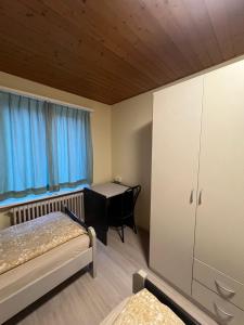 Niederdorf, Baselland Hotel في Niederdorf: غرفة نوم بسرير ومكتب وطاولة