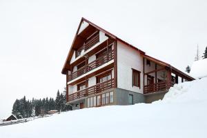 un edificio con nieve delante en Woodvel House en Palyanytsya