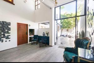 a living room with a green couch and chairs at Siete Puertas Coyoacán in Mexico City
