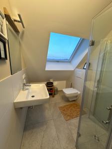 a bathroom with a sink and a toilet and a window at Ferienwohnungen Hamminkeln, Berg4Home in Hamminkeln