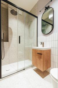 a bathroom with a shower and a sink and a mirror at Stylowy loft w kamienicy przy Dworcu PKP in Radom