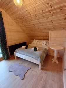 a bedroom with a bed and a table in a cabin at Domki po balu 