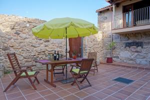a table and chairs with a yellow umbrella on a patio at Casa Del Ingles - Luxury Private Village & Pool in Rural Valley in Pontevedra