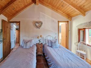 two beds in a bedroom with wooden ceilings at Casa Del Ingles - Luxury Private Village & Pool in Rural Valley in Pontevedra