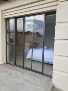 a room with sliding glass doors with a bed inside at M & N Guest House in Ermelo