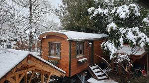 una pequeña casa de madera con nieve en el techo en Central Starnberg and surrounded by nature, en Starnberg