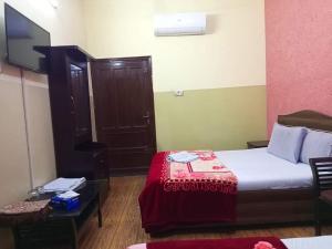 Habitación de hotel con cama y TV en Furnish Rooms Near Jinnah Airport en Karachi