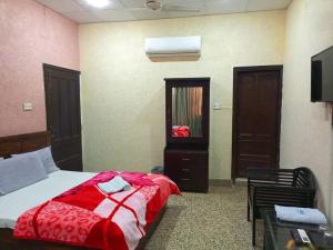 Un dormitorio con una cama con una manta roja. en Furnish Rooms Near Jinnah Airport en Karachi