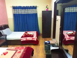 Furnish Rooms Near Jinnah Airport في كراتشي: غرفة بسريرين ومرآة