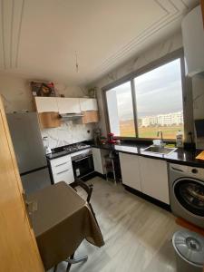 uma pequena cozinha com um lavatório e uma janela em Appartement neuf et élégant em Fez