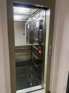 - un ascenseur en verre dans un bâtiment avec un miroir dans l'établissement Appartement neuf et élégant, à Fès