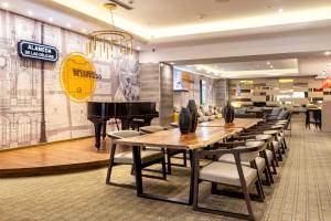 ein Restaurant mit einem Klavier, Tischen und Stühlen in der Unterkunft Le Méridien Santiago by Marriott in Santiago