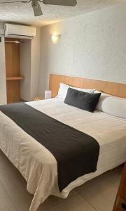 ein Schlafzimmer mit einem großen Bett mit einer schwarzen Decke in der Unterkunft Hotel Emperador centro Guadalajara y Remodelado in Guadalajara
