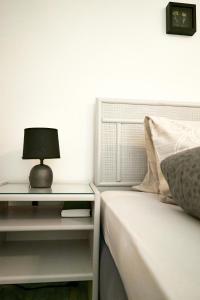 Una cama con mesita de noche con una lámpara. en Tripple Room with Bathroom., en Därligen