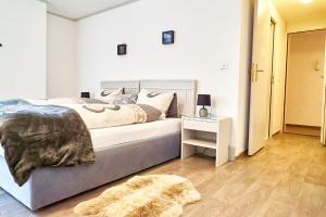 a bedroom with a bed and a night stand with a rug at Tripple Room with Bathroom. in Därligen