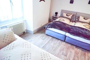 a bedroom with two beds and a wooden floor at Tripple Room with Bathroom. in Därligen