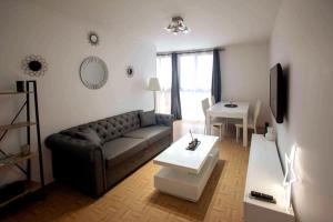 een woonkamer met een bank en een tafel bij Appartement neuf 3 ch équipé in Thiais