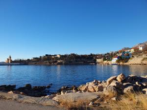 a large body of water with rocks and houses at Apartman Nina in Karlobag