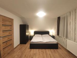 1 dormitorio con 1 cama y suelo de madera en Chata Závažka en Závažná Poruba