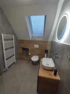 a bathroom with a toilet and a sink and a window at Chata Závažka in Závažná Poruba