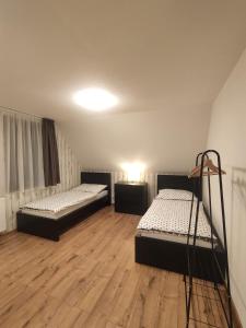 two beds in a room with wooden floors at Chata Závažka in Závažná Poruba