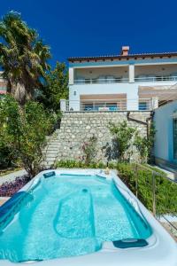 una piscina frente a un edificio en Villa K Dubrovnik-5 bedroom villa with sea access, en Zaton