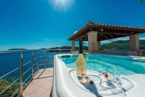 bañera con botella de vino en el balcón en Villa K Dubrovnik-5 bedroom villa with sea access, en Zaton