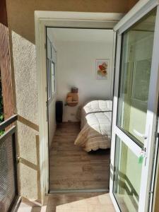 a door leading to a bedroom with a bed at La Fragua Suites Saavedra in El Bolsón