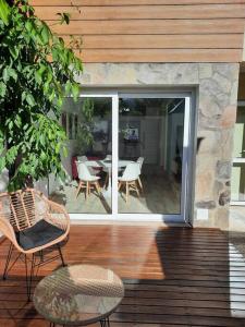 a patio with a table and chairs on a wooden deck at La Fragua Suites Saavedra in El Bolsón