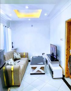 a living room with a couch and a flat screen tv at Swift Haven Studio Bamburi in Mombasa