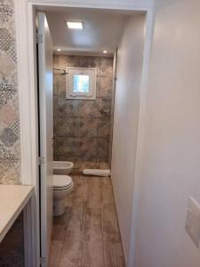 a small bathroom with a toilet and a window at La Fragua Suites Saavedra in El Bolsón +17 photos