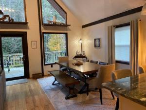uma sala de estar com uma mesa de jantar e cadeiras em Cozy Poconos retreat on Bushkill Creek w/ Firepit! em East Stroudsburg