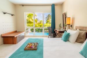 una camera con letto, scrivania e finestra di Physacap Suites & Villas a Le François