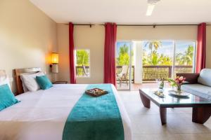 a bedroom with a large bed and a couch at Villa Physacap in Le François