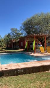 a swimming pool with a gazebo and two chairs at Cabaña Chañares de Banda Florida - Ama in Villa Unión